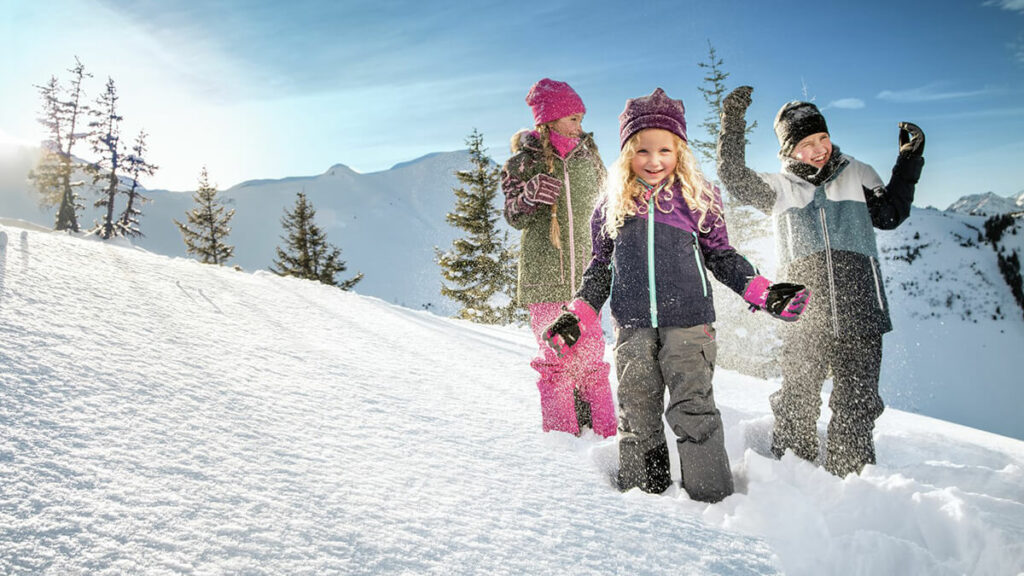 kids playing snow in slopes